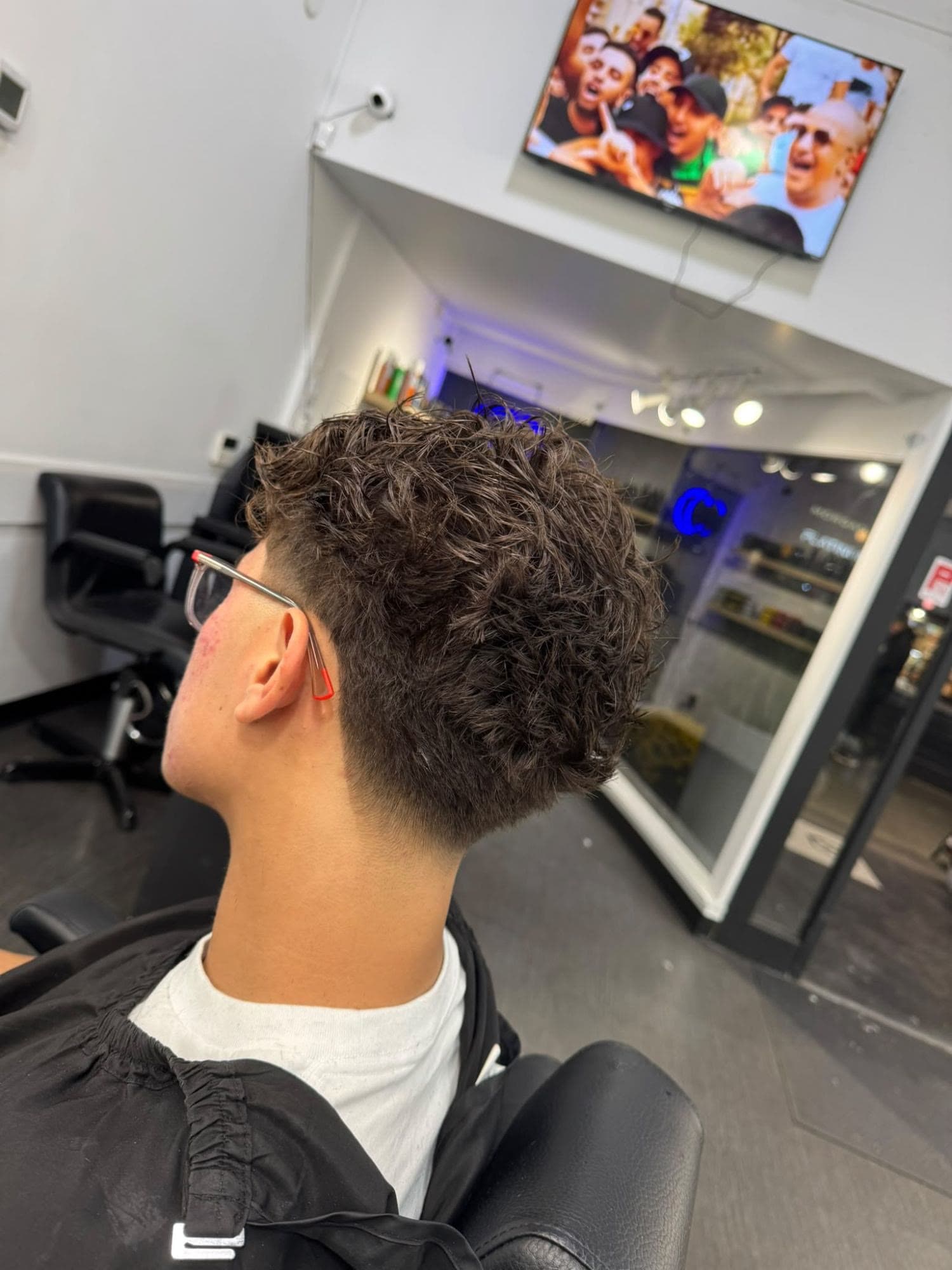 Curly top with a taper fade at Glasscut Barbershop